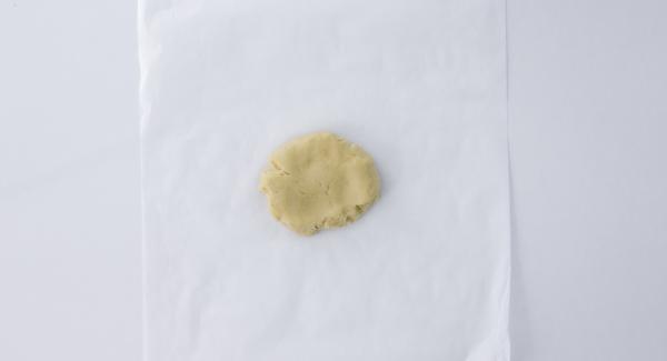Disporre l’impasto tra due fogli di carta da forno.