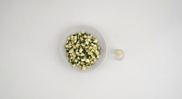 Lavare le zucchine e tagliarle a dadini. Sbucciare lo spicchio d'aglio e pulire i gamberi eliminando il filo nero.
