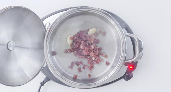 Al suono di Audiotherm, impostare Navigenio a livello 2 e aggiungere l’olio, l’aglio, il prosciutto, i pinoli e l’uvetta. Mescolare brevemente.