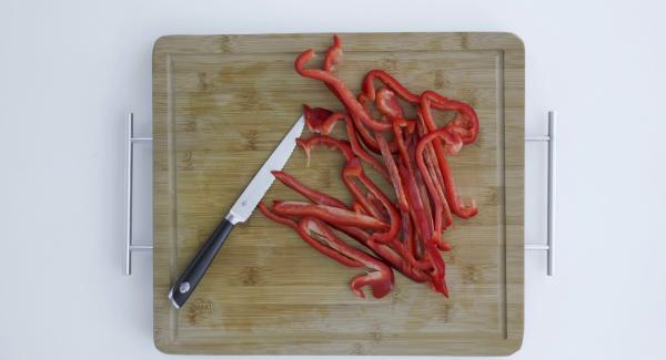 Tagliare i peperoni a striscioline e metterle nell’Unità di cottura. Distribuirvi sopra i dadini di pomodoro, cipolla e aglio e irrorare il tutto con 2 cucchiaini di olio di oliva.