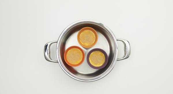 Cospargere con zucchero di canna la superficie della crème brulée e metterne 3 all’interno dell’Inserto “2 in 1“. Posizionare l’Inserto “2 in 1“ nel coperchio capovolto dell’Unità e coprirlo con Navigenio rivolto verso il basso, impostato a livello I.