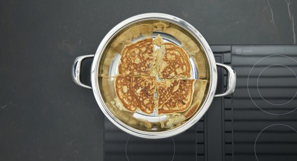 Spegnere il calore. Tagliare in quattro la frittata e girarla (se la pastella non è cotta a sufficienza, coprire con il coperchio e attendere un poco).