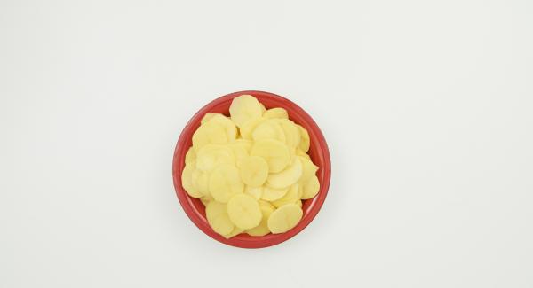 Pelare le patate, affettarle sottilmente e trasferirle in NonSoloForno. Versarvi sopra il composto di panna e latte e coprire con il coperchio.