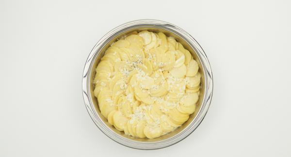 Pelare le patate, affettarle sottilmente e trasferirle in NonSoloForno. Versarvi sopra il composto di panna e latte e coprire con il coperchio.