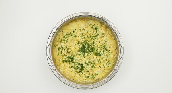 Tritare finemente le foglie di prezzemolo, togliere il coperchio, distribuire sul gratin il prezzemolo e il parmigiano e cuocere senza coperchio per ulteriori 10 minuti.