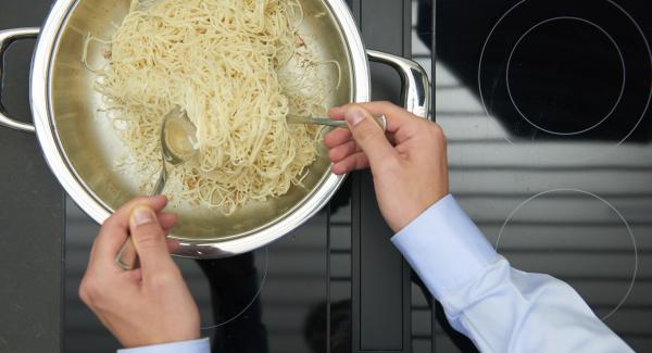 Rosolare la pasta a calore vivace e toglierla. Rosolare brevemente anche i cipollotti, il pomodoro, il peperoncino, l’aglio e lo zenzero. Aggiungere i gamberetti e continuare la cottura.