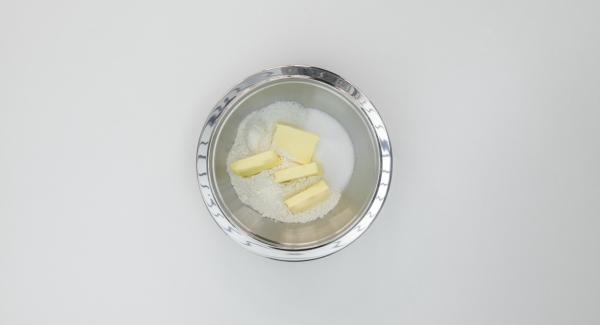 Versare in una scodella la farina, le scaglie di cocco, lo zucchero, il sale e il burro e lavorare finché si formano delle briciole. Mettere in frigo per 30 minuti circa.