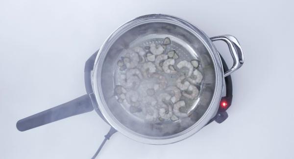 Al suono di Audiotherm, aggiungere olio, aglio e peperoncino. Soffriggere per 5 secondi e aggiungere i gamberi.