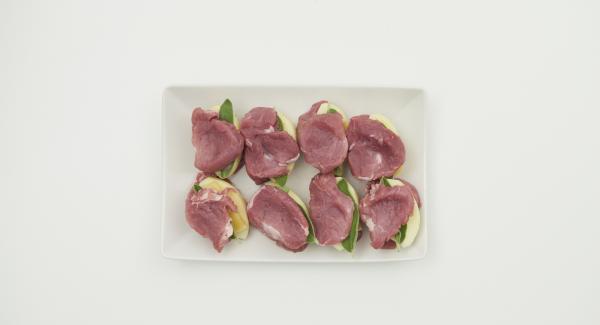 Riempire ciascun medaglione con un pezzetto di formaggio, uno di mela e una foglia di salvia. Infine, avvolgere il medaglione in una fetta di prosciutto.