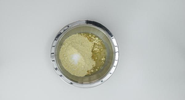 Versare la farina e il sale in un’ampia bacinella. Aggiungere circa 500 ml di brodo di gamberi fino a ottenere una pastella fluida.