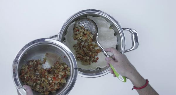 Versare il ripieno di carne e stendere la pasta restante in un disco. Posizionarlo sopra il ripieno e chiudere bene i bordi. Punzecchiare più volte la pasta con una forchetta. Sbattere il tuorlo con un po’ d’acqua e spennellarlo uniformemente sulla pasta.