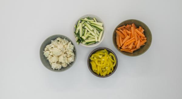 Pelare le carote, mondare le zucchine e il peperone e tagliarli a striscioline. Mondare il cavolfiore e dividerlo in cimette.