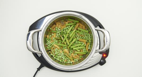 Al suono di Audiotherm, mettere nella pentola la salsiccia, la carne macinata e rosolare. Sfumare con il vino bianco. Mescolare i fusilli, il brodo, i piselli e metà degli asparagi. Chiudere Secuquick.