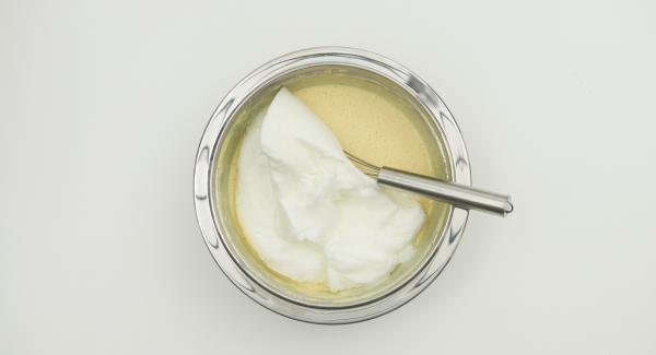 In una bacinella, mescolare i tuorli con 150 g di yogurt. Unire la farina con il lievito e mescolare aggiungendo a filo il latte. Infine, unire gli albumi montati a neve.