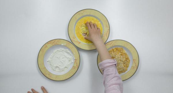 Passare le fette di pomodoro dapprima nella farina, poi nelle uova e, infine, nel miscuglio di pangrattato e cornflakes.
