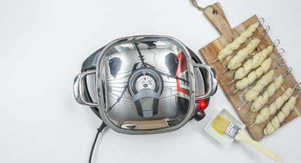Spennellare con un filo d’olio i 4 spiedini su ogni lato. Al suono di Audiotherm, abbassare Navigenio a livello 2 e inserire gli spiedini all'interno dell'Unità. Coprire nuovamente con il coperchio e proseguire la cottura per ca. 4 minuti. Spennellare con un filo d’olio i 4 spiedini su ogni lato. Al suono di Audiotherm, abbassare Navigenio a livello 2 e inserire gli spiedini all'interno dell'Unità. Coprire nuovamente con il coperchio e proseguire la cottura per ca. 4 minuti.