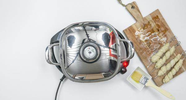 Spennellare con un filo d’olio i 4 spiedini su ogni lato. Al suono di Audiotherm, abbassare Navigenio a livello 2 e inserire gli spiedini all'interno dell'Unità. Coprire nuovamente con il coperchio e proseguire la cottura per ca. 4 minuti. Spennellare con un filo d’olio i 4 spiedini su ogni lato. Al suono di Audiotherm, abbassare Navigenio a livello 2 e inserire gli spiedini all'interno dell'Unità. Coprire nuovamente con il coperchio e proseguire la cottura per ca. 4 minuti.