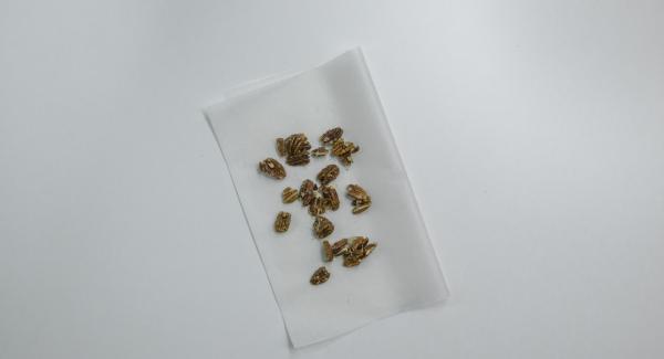 Aggiungere le noci pecan, adagiare il composto sulla carta da forno e lasciar raffreddare.