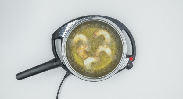 Togliere il coperchio, estrarre i gamberi e scolare su carta da cucina. Friggere i restanti gamberi allo stesso modo. Togliere il coperchio, estrarre i gamberi e scolare su carta da cucina. Friggere i restanti gamberi allo stesso modo.
