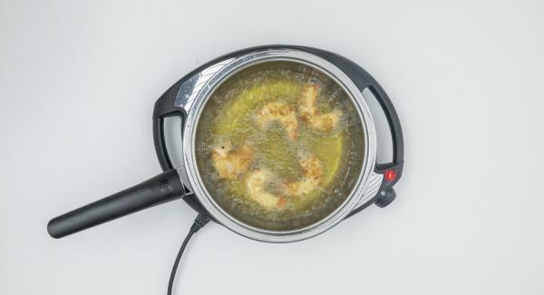 Togliere il coperchio, estrarre i gamberi e scolare su carta da cucina. Friggere i restanti gamberi allo stesso modo. Togliere il coperchio, estrarre i gamberi e scolare su carta da cucina. Friggere i restanti gamberi allo stesso modo.
