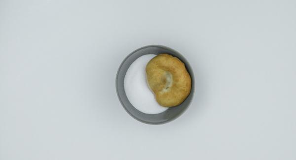 Rotolare le frittelle nello zucchero e servirle ancora calde.
