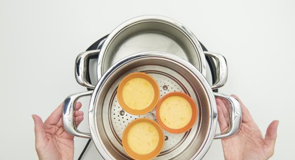 Riempire 6 ciotoline in acciaio o ceramica di ca. 150 ml fino a ¾ del volume. Versare ca. 150 ml di acqua nell’Unità di cottura e collocare l’inserto “2 in 1“ con le prime 3 ciotole al suo interno.
Coprire l’Inserto “2 in 1” con EasyQuick e posizionare l’Unità su Navigenio impostato in modalità "A". Posizionare Audiotherm sulla finestra “vapore” dopo aver impostato un tempo di cottura di 6 minuti. Riempire 6 ciotoline in acciaio o ceramica di ca. 150 ml fino a ¾ del volume. Versare ca. 150 ml di acqua nell’Unità di cottura e collocare l’inserto “2 in 1“ con le prime 3 ciotole al suo interno.
Coprire l’Inserto “2 in 1” con EasyQuick e posizionare l’Unità su Navigenio impostato in modalità "A". Posizionare Audiotherm sulla finestra “vapore” dopo aver impostato un tempo di cottura di 6 minuti.