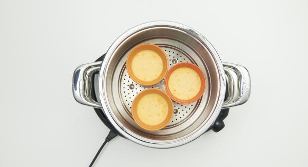 Riempire 6 ciotoline in acciaio o ceramica di ca. 150 ml fino a ¾ del volume. Versare ca. 150 ml di acqua nell’Unità di cottura e collocare l’inserto “2 in 1“ con le prime 3 ciotole al suo interno.
Coprire l’Inserto “2 in 1” con EasyQuick e posizionare l’Unità su Navigenio impostato in modalità "A". Posizionare Audiotherm sulla finestra “vapore” dopo aver impostato un tempo di cottura di 6 minuti. Riempire 6 ciotoline in acciaio o ceramica di ca. 150 ml fino a ¾ del volume. Versare ca. 150 ml di acqua nell’Unità di cottura e collocare l’inserto “2 in 1“ con le prime 3 ciotole al suo interno.
Coprire l’Inserto “2 in 1” con EasyQuick e posizionare l’Unità su Navigenio impostato in modalità "A". Posizionare Audiotherm sulla finestra “vapore” dopo aver impostato un tempo di cottura di 6 minuti.