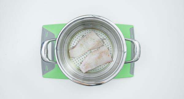 Tagliare a metà il filetto di pesce, insaporirlo con sale e pepe e adagiarlo nell’inserto "2 in 1". Lavare il limone, tagliarlo a fette e disporle sopra il pesce.