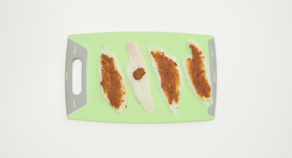 Grattugiare la scorza di mezzo limone e mescolarla bene con il trito di frutta secca, la salsa al peperoncino e la rimanente colatura di alici. Asciugare i filetti di pesce e spalmare il composto uniformemente su tutte le fette. Arrotolare il pesce e disporlo sull'inserto Softiera.