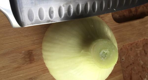 Togliere il primo strato di buccia esterna della cipolla e poi tagliare la parte superiore.