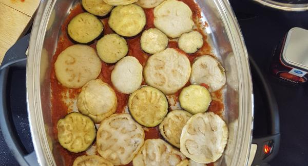 Fare strati con melanzane fritte, mozzarella, grana e pomodoro;