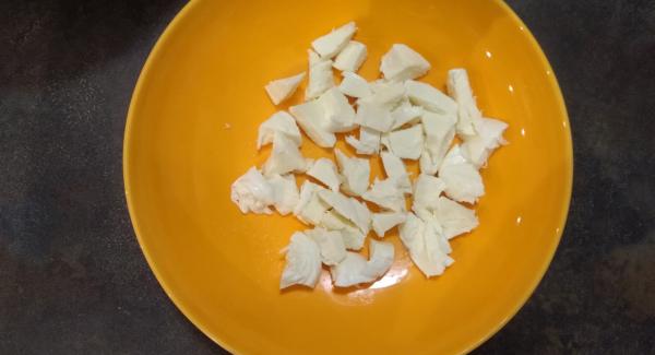 Tagliare a pezzettini (circa 30, uno per ogni polpetta) la mozzarella.