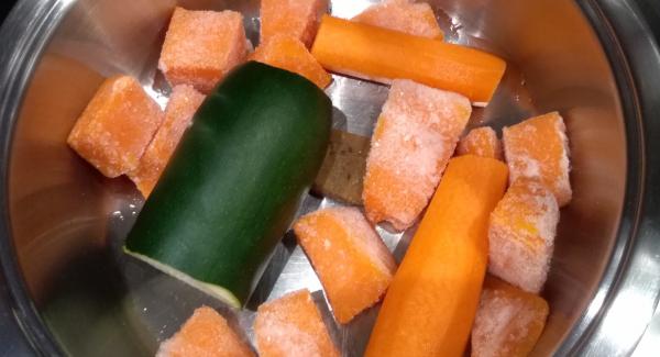 Inserire nella unità di cottura i cubotti di zucca surgelati, la zucchina e la carota tagliate in due, il dado e l'acqua.